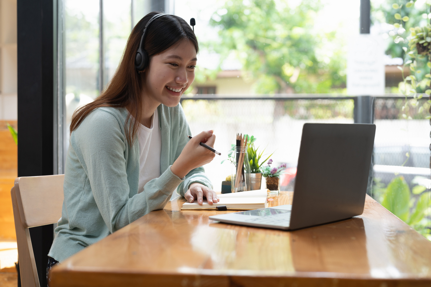 Smiling girl student wear wireless headphone study online wi