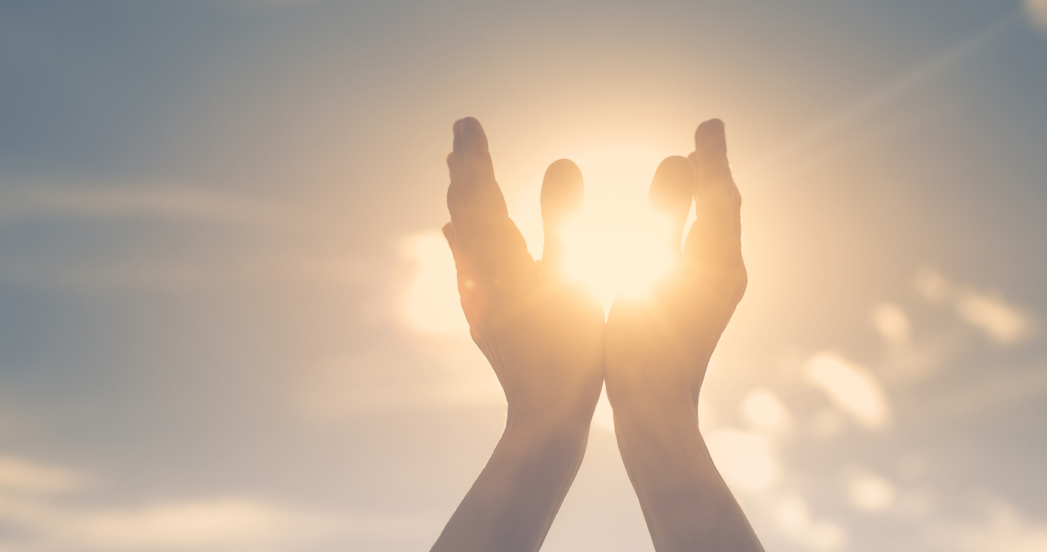 Persons hand holding sun in palm feeling energized. Spiritual, mind, body concept.